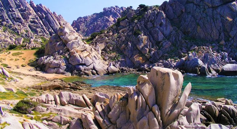Wind-sculpted pink granite boulders above a turquoise cove at Capo Testa near Santa Teresa Gallura on a small-group sardinia hiking tour to Moon Valley